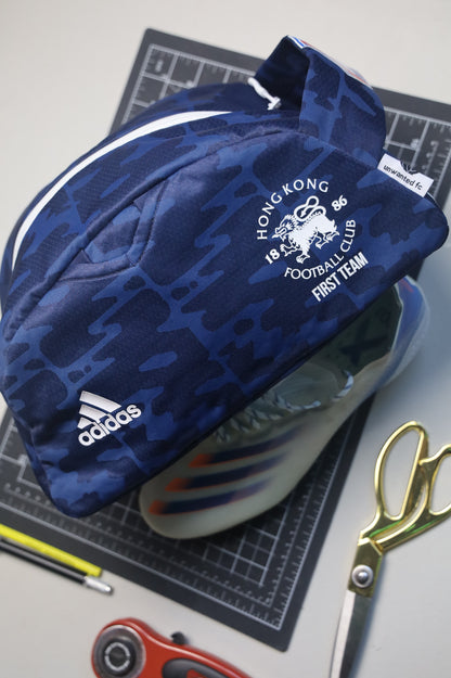 Blue Adidas bag with Hong Kong Football Club logo on a cutting mat with scissors and other items.